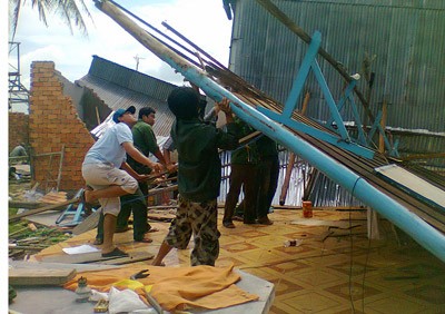 Local residents clear debris of a collapsed house after the landslide along the Hau River bank in An Giang Province on May 26